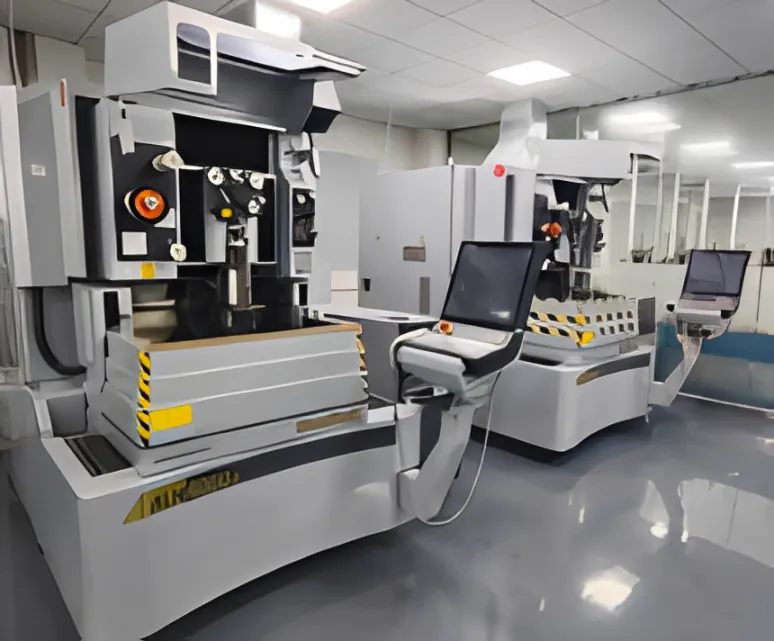 A large grey machining center with a control pendant.